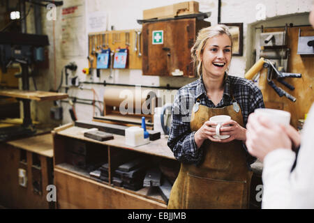 Two young craftswomen chatting in pipe organ workshop Stock Photo