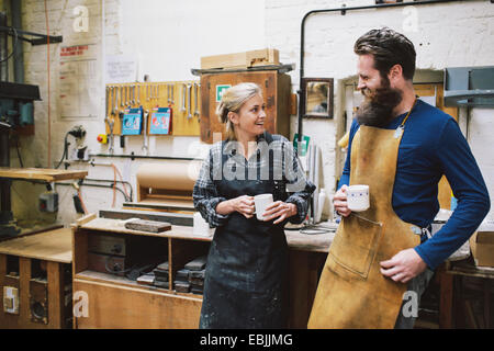 Craftsman and woman chatting in pipe organ workshop Stock Photo