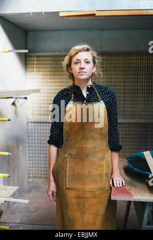 Portrait of young craftswoman in organ workshop Stock Photo