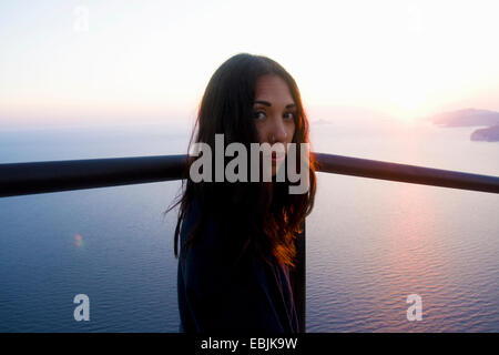 Portrait of young woman looking over her shoulder at coast, Marseille, France Stock Photo