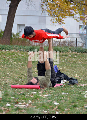 A couple doing balancing exercises in Washington Square Park in Greenwich Village, Manhattan, New York City Stock Photo