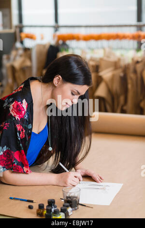 Young seamstress painting fashion design in workshop Stock Photo