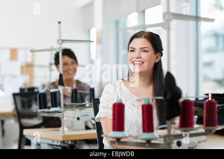 Portrait of young seamstress using sewing machine in workshop Stock Photo