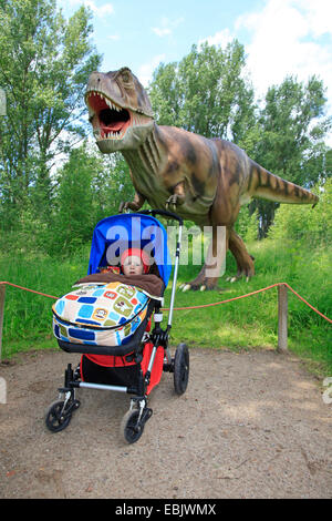 Tyrannosaurus (Tyrannosaurus rex), with buggy in a dino park/pulling the buggy Stock Photo