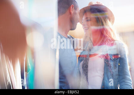 Young couple standing face to face, seen through window Stock Photo