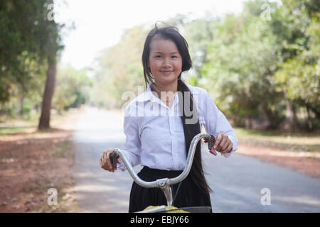 Cambodia girl with her bike on country road, Siem Reap, Cambodia Stock Photo