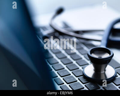 Close up of stethoscope on top of laptop computer keyboard on doctors desk Stock Photo