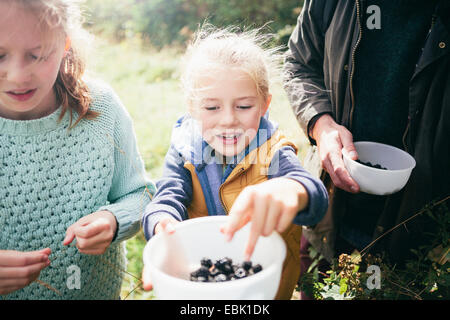 Two girls holding blackberries in bowl Stock Photo