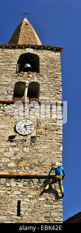 man climbing up the steeple during the guide feast, France, Savoie, Val d IsÞre Stock Photo