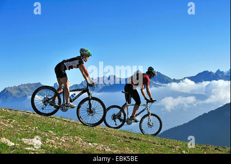 two mountain biker on mountain meadow enjoying the mountain scenery, France, Savoie, La Plagne Stock Photo
