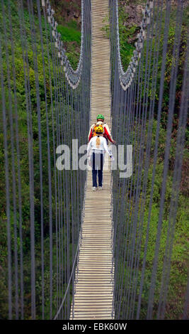 two hikers walking a suspension bridge, France, Mercantour National Park, Lantosque Stock Photo