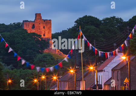 Norham Castle in north Northumberland and the village of the same name at dusk, England Stock Photo