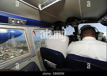 view over the shoulders of two pilots of a propeller plane flying along the Atlantik coast, Honduras Stock Photo