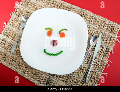 symbol picture 'diet': some pieces of vegetable and fruit forming a face on a plate Stock Photo