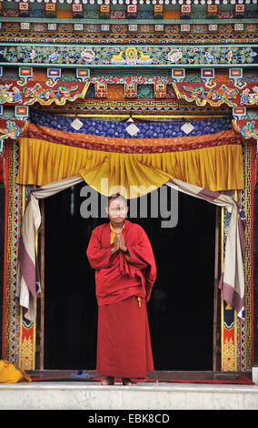 monk at an entrance of  the stupa of Bouddhanath, one of the holiest Buddhist sites of the country, Nepal, Bodnath, Kathmandu Stock Photo