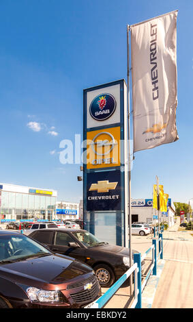 Official dealership signs and flags against blue sky Stock Photo