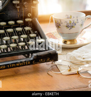 Studio shot of antique typewriter with teacup and eyeglasses Stock Photo