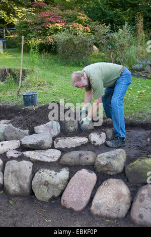 building a rockery for herbs in the garden, Germany Stock Photo