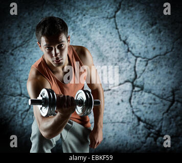 young man with dumbbell flexing biceps Stock Photo