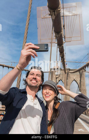 USA, New York State, New York City, Brooklyn, Happy couple taking selfie on Brooklyn Bridge Stock Photo