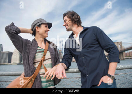 USA, New York State, New York City, Brooklyn, Happy couple standing and leaning against railing