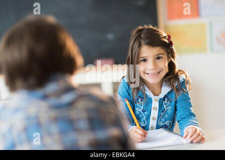 Pupils (6-7) learning in classroom, Girl (6-7) looking at camera Stock Photo