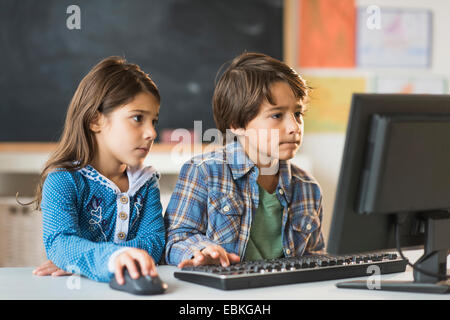 Pupils (6-7) using computer in classroom Stock Photo
