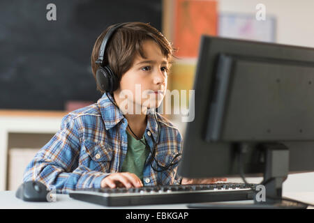 Schoolboy (6-7) using computer in classroom Stock Photo