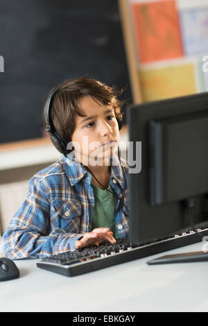 Schoolboy (6-7) using computer in classroom Stock Photo