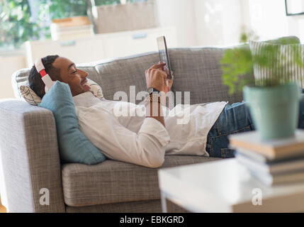 Man relaxing on sofa with tablet pc Stock Photo