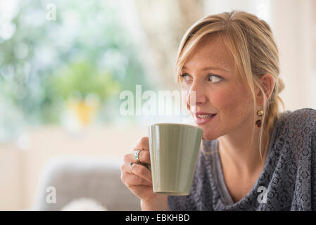 Pensive woman drinking coffee Stock Photo