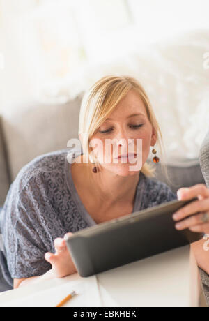 Woman lying down on sofa with tablet pc Stock Photo