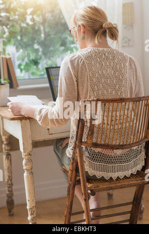 Rear view of woman working with laptop Stock Photo