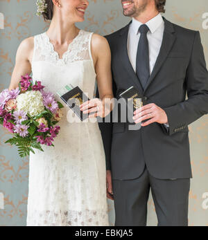 Happy bride and groom posing with passports Stock Photo