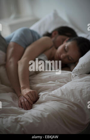 Couple sleeping together in bed at night Stock Photo