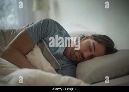 Man sleeping in bed Stock Photo