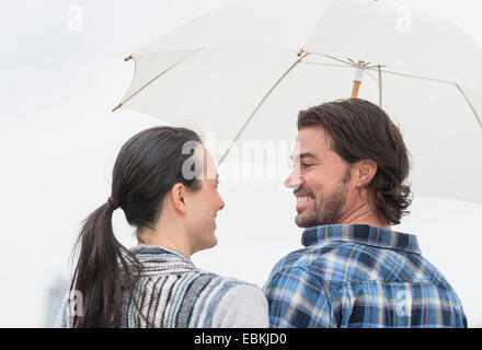 Rear view of couple under umbrella