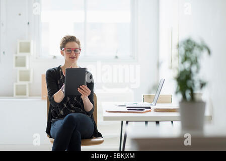 Businesswoman using digital tablet in office Stock Photo