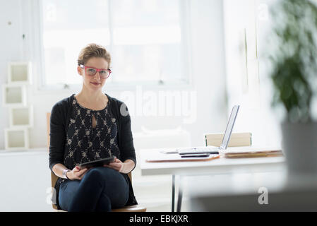 Portrait of businesswoman using digital tablet in office Stock Photo