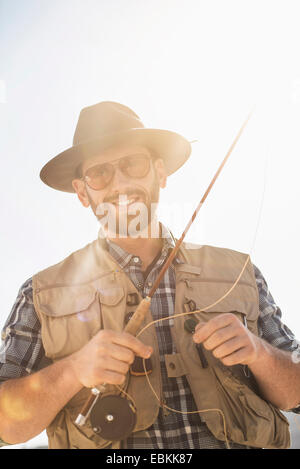 Portrait of man holding fishing rod Stock Photo