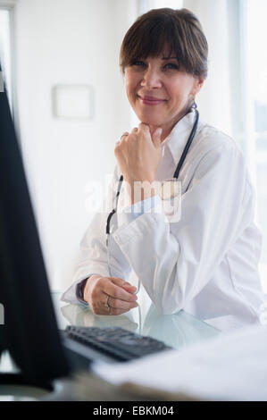 Portrait of doctor sitting at desk Stock Photo