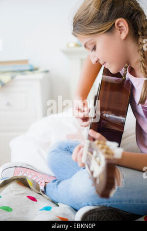 Girl (12-13) playing guitar Stock Photo