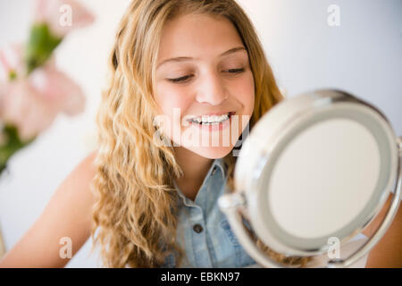 Girl (12-13) smiling to mirror Stock Photo