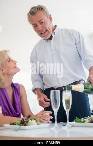 Portrait of man pouring champagne at restaurant table Stock Photo