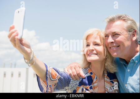 Portrait of couple posing for smartphone selfie