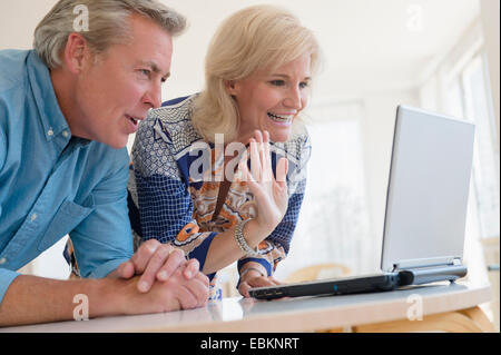 Portrait of couple looking at laptop screen Stock Photo