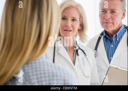 Close-up shot of two doctors talking to female patient Stock Photo