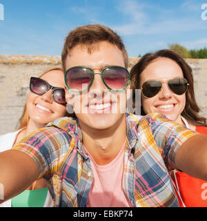 group of smiling friends taking selfie outdoors Stock Photo