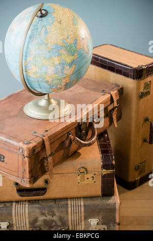 Studio shot of globe on suitcases Stock Photo
