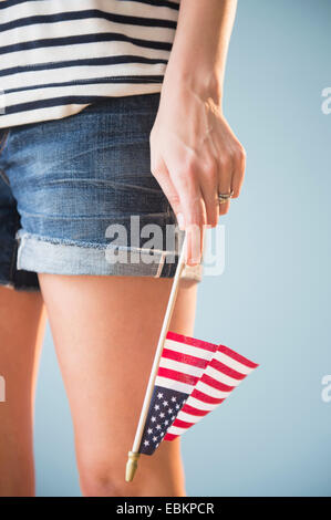 Studio shot of woman's hand holding American flag Stock Photo